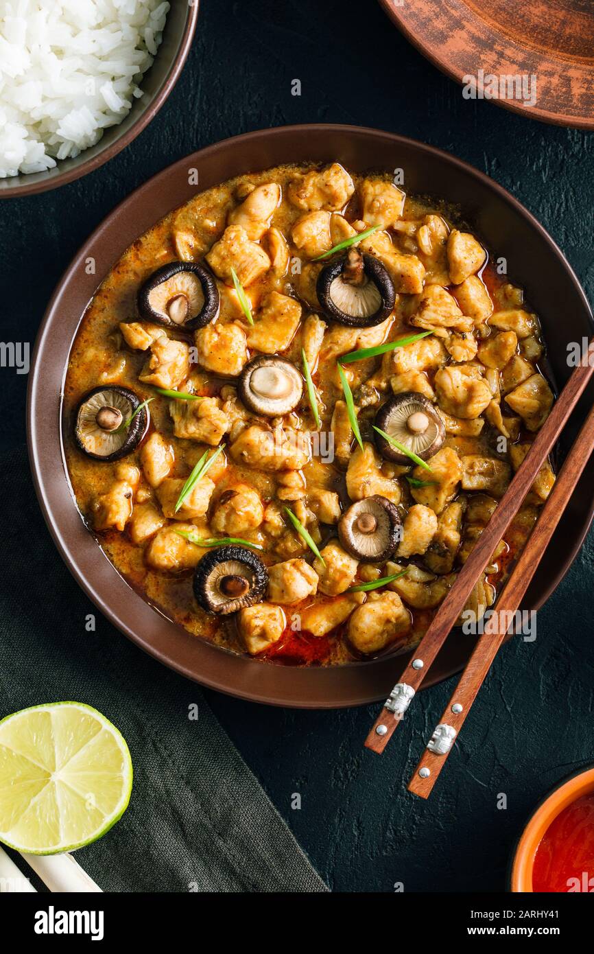 Panang Gai, deliciosa comida tailandesa picante de pollo con setas shiitaki sobre un fondo negro Foto de stock