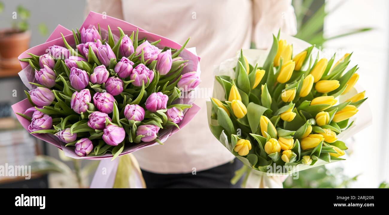 Dos hermosos ramos de tulipanes en manos de mujeres. El trabajo de la  floristería en una floristería. Entrega flor fresca cortada. Tienda floral  europea Fotografía de stock - Alamy