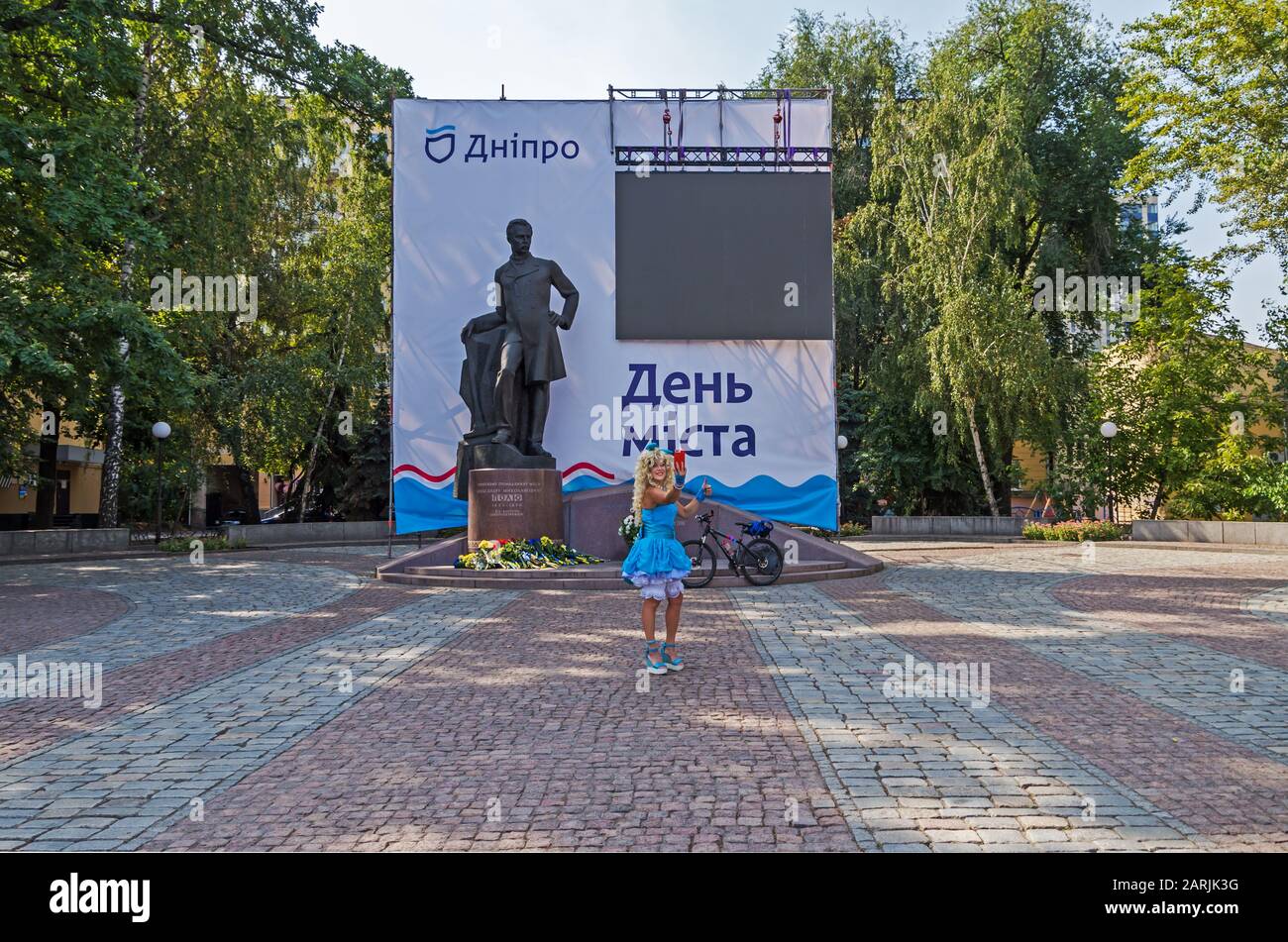 Dnipro, Ucrania - 14 de septiembre de 2019: Chica en traje de cuento de hadas carácter Malvina toma selfie en el monumento de fondo a Alexander Pol. Inscripción r Foto de stock