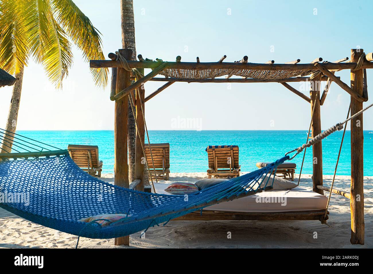 Vista panorámica de un hermoso día soleado en la playa tropical de arena en las Maldivas. Concepto de viaje. Relajarse en la clásica hamaca de color azul. Foto de stock