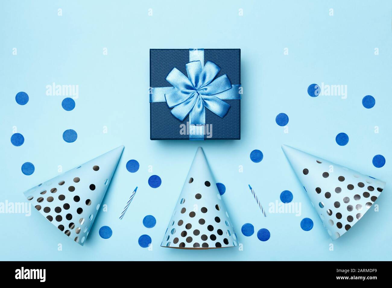 Cumpleaños azul fondo composición con fiesta regalo obsequio gorras confetti velas top vista plano laico. Foto de stock