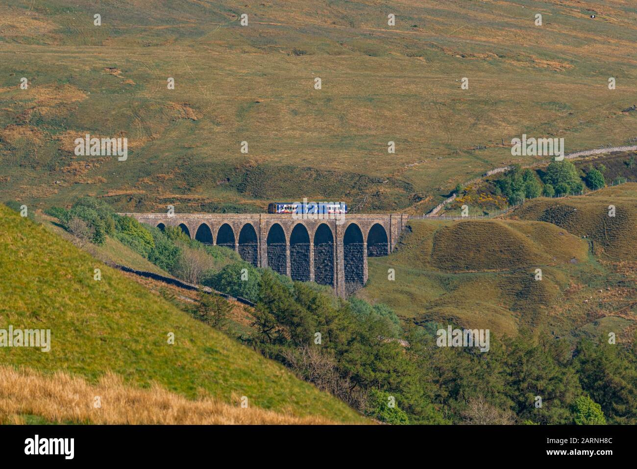 Cerca de Cowgill, Cumbria, Inglaterra, Reino Unido - 16 de mayo de 2019: Un tren que pasa por el viaducto Arten Gill en la línea de ferrocarril Settle-Carlisle Foto de stock
