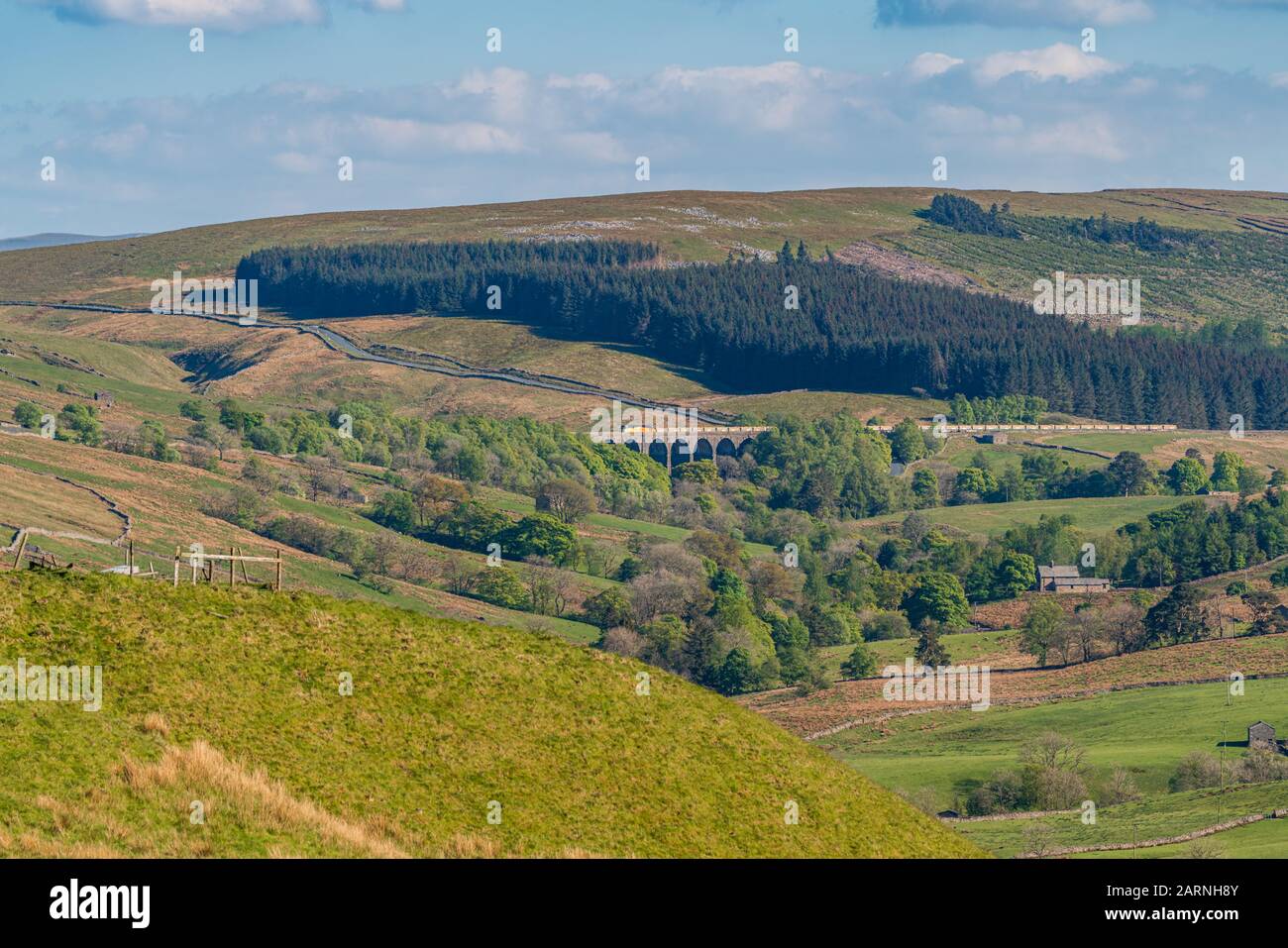 Cerca de Cowgill, Cumbria, Inglaterra, Reino Unido - 16 de mayo de 2019: Un tren que pasa por el viaducto Dent Head en la línea de ferrocarril Settle-Carlisle Foto de stock
