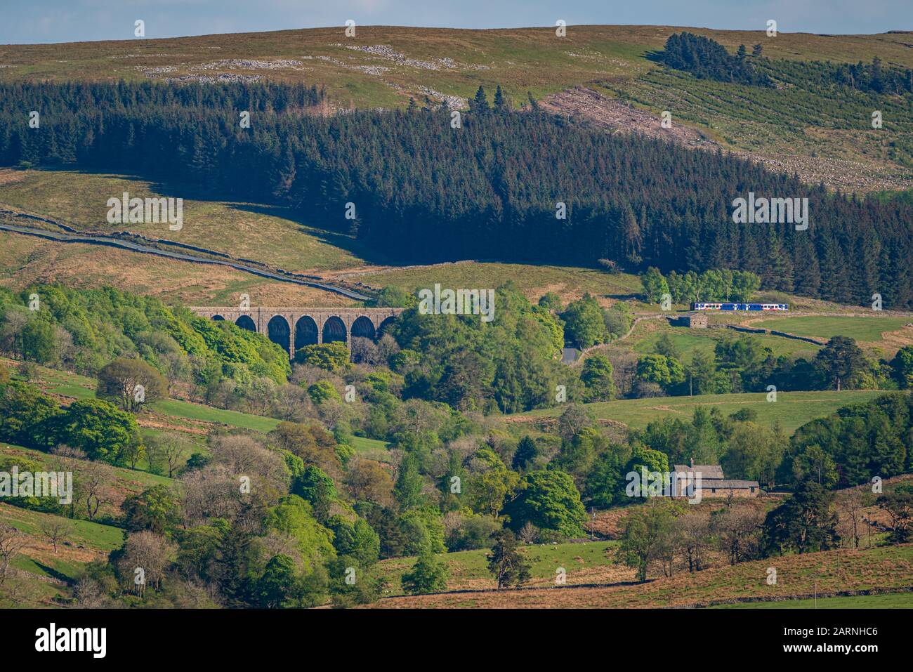 Cerca de Cowgill, Cumbria, Inglaterra, Reino Unido - 16 de mayo de 2019: Un tren que pasa por el viaducto Dent Head en la línea de ferrocarril Settle-Carlisle Foto de stock