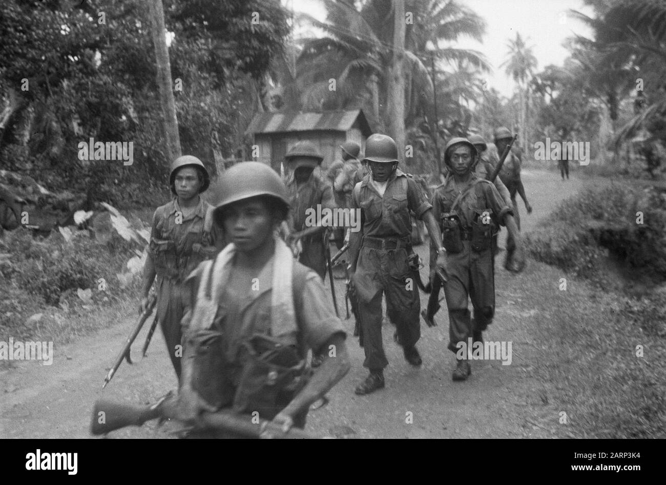la marcha de Tapanoeli, Tarutoeng, Sibolga, Padang, Sidempoean En un kampong, una emboscada fue descubierta por japoneses abandonados. Después de un breve tiroteo, en el que uno de nuestros soldados mató al soldado javanés Ranoe de primera clase, el enemigo huye. Una nueva patrulla se marcha para rastrear y desactivar el enemigo anotación: DJK Fecha: Diciembre 1948 ubicación: Indonesia, Dutch East Indies, Sumatra Foto de stock