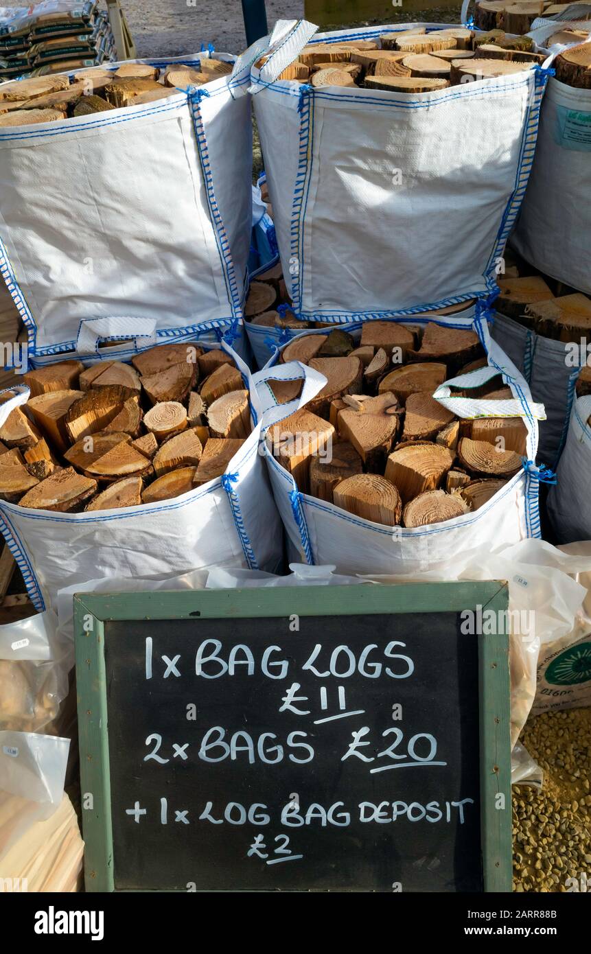 Con un precio de enero de 2020, bolsas de combustible de invierno de troncos secos para la venta en una tienda de la granja Foto de stock