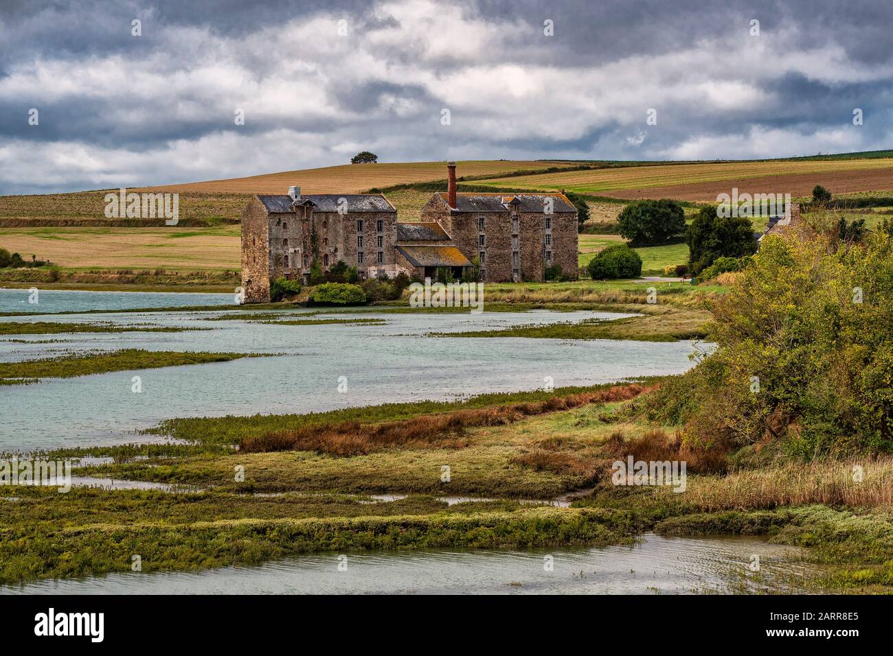 Bretagne, norte de Francia. Una antigua fábrica abandonada cerca de la ciudad de Saint Malo en medio del verde campo y un pantano. Foto de stock