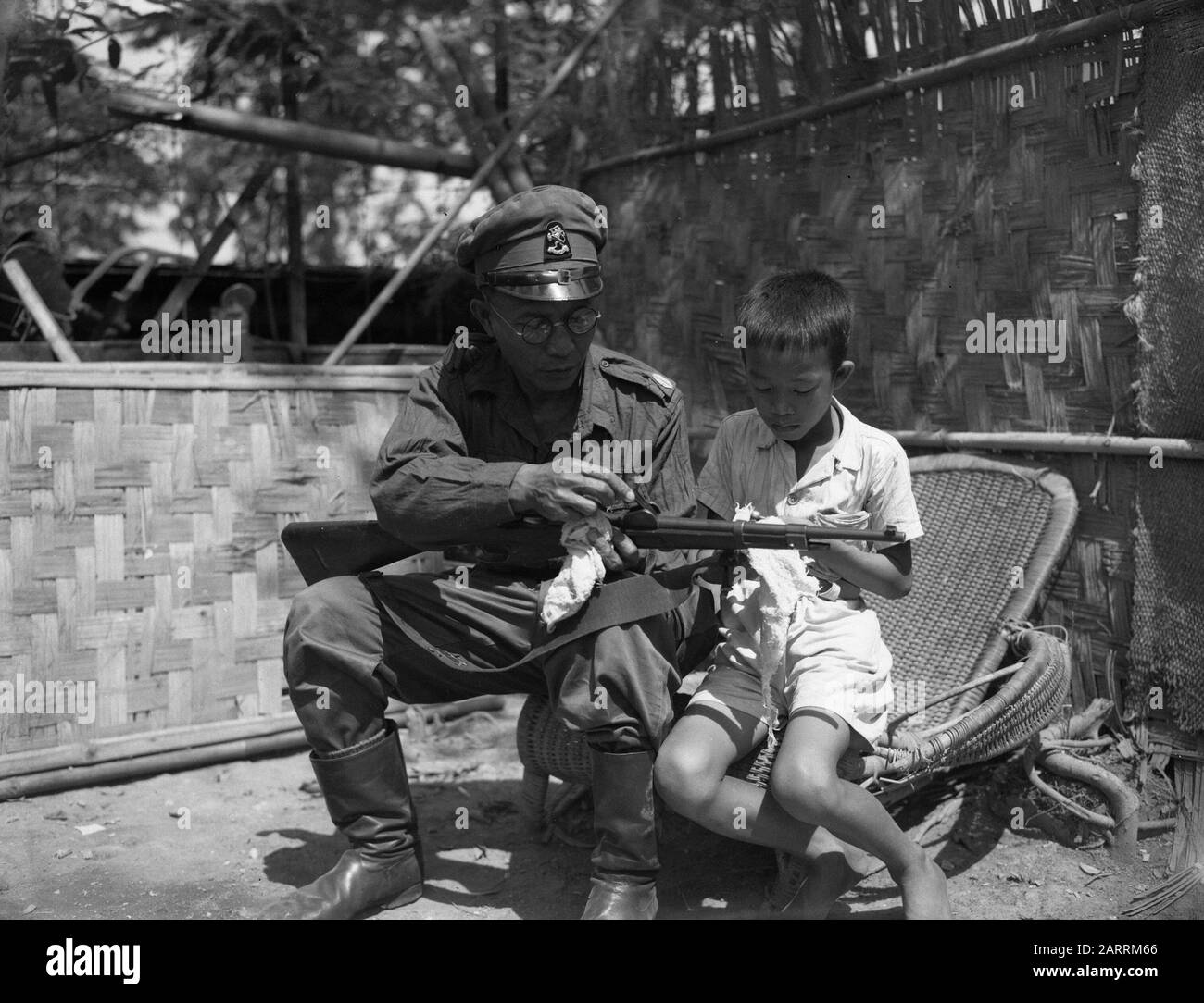 El Sargento Bagino hace junto con un niño (hijo?) su rifle limpio Fecha:  Octubre 1946 lugar: Indonesia, Dutch East Indies Fotografía de stock - Alamy