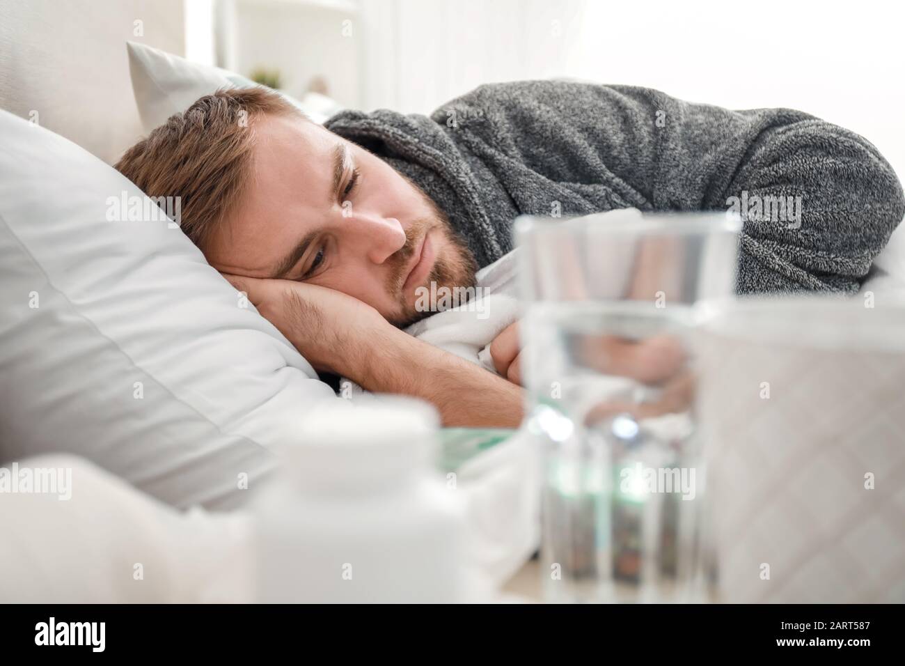 El hombre enfermo con gripe acostado en la cama Fotografía de stock - Alamy
