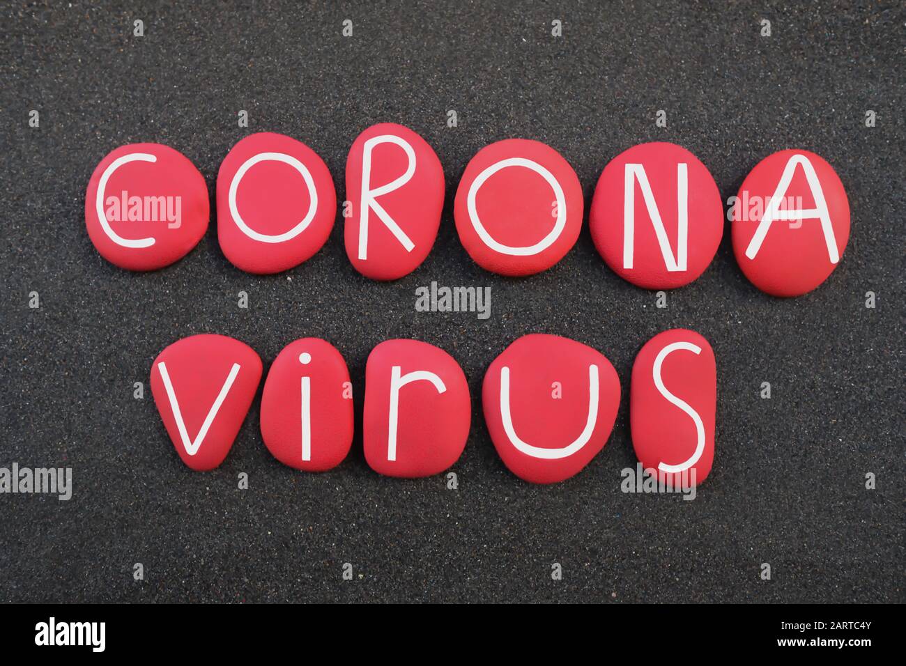 Coronavirus, virus infeccioso de la bronquitis palabra compuesta de letras de piedra de color rojo sobre arena volcánica negra Foto de stock