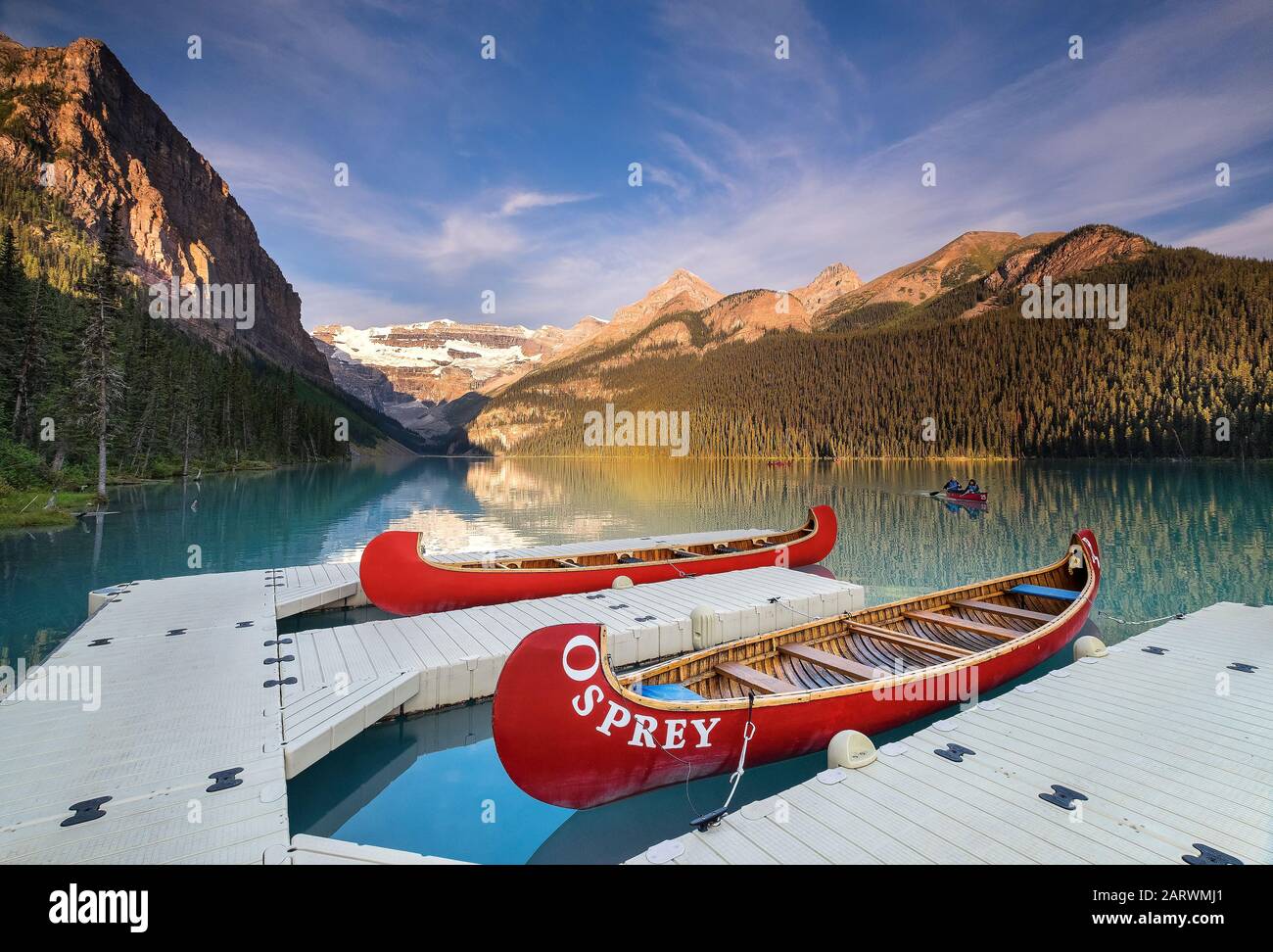Regreso en canoa al embarcadero en Sunrise on Lake Louise, respaldado por el glaciar Victoria, el lago Louise, el Parque Nacional Banff, Alberta, Canadá Foto de stock