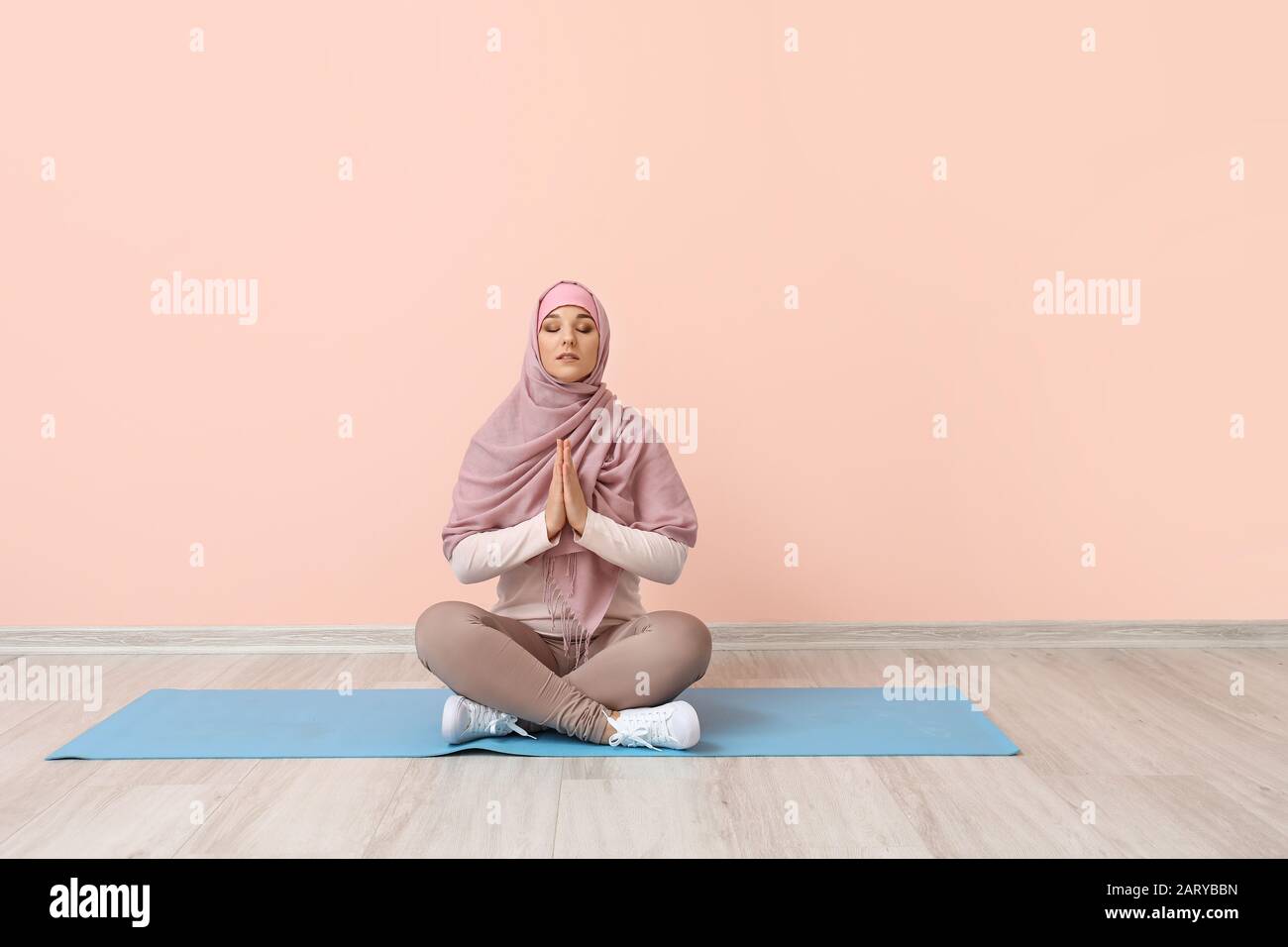 Mujer Musulmana Deportiva Que Practica Yoga Cerca De La Pared De