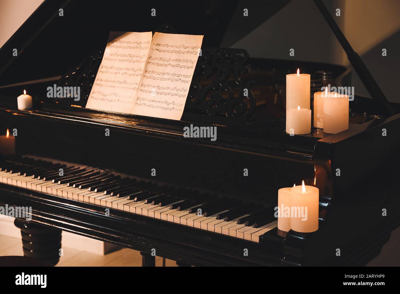 Elegante piano de cola con velas encendidas por la noche Fotografía de  stock - Alamy
