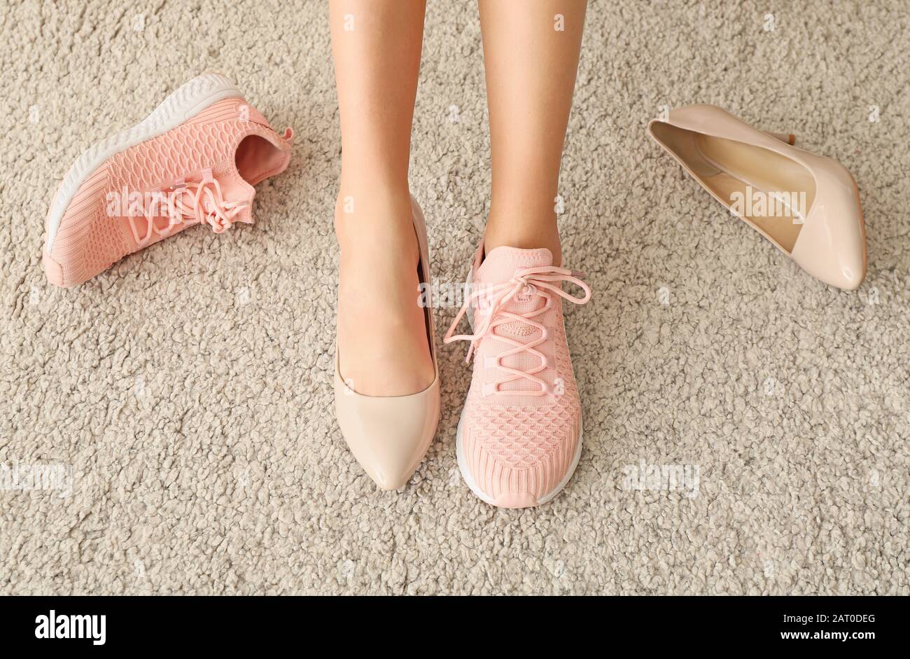 Mujer joven cambiando los zapatos de tacón alto para cómodos en casa  Fotografía de stock - Alamy
