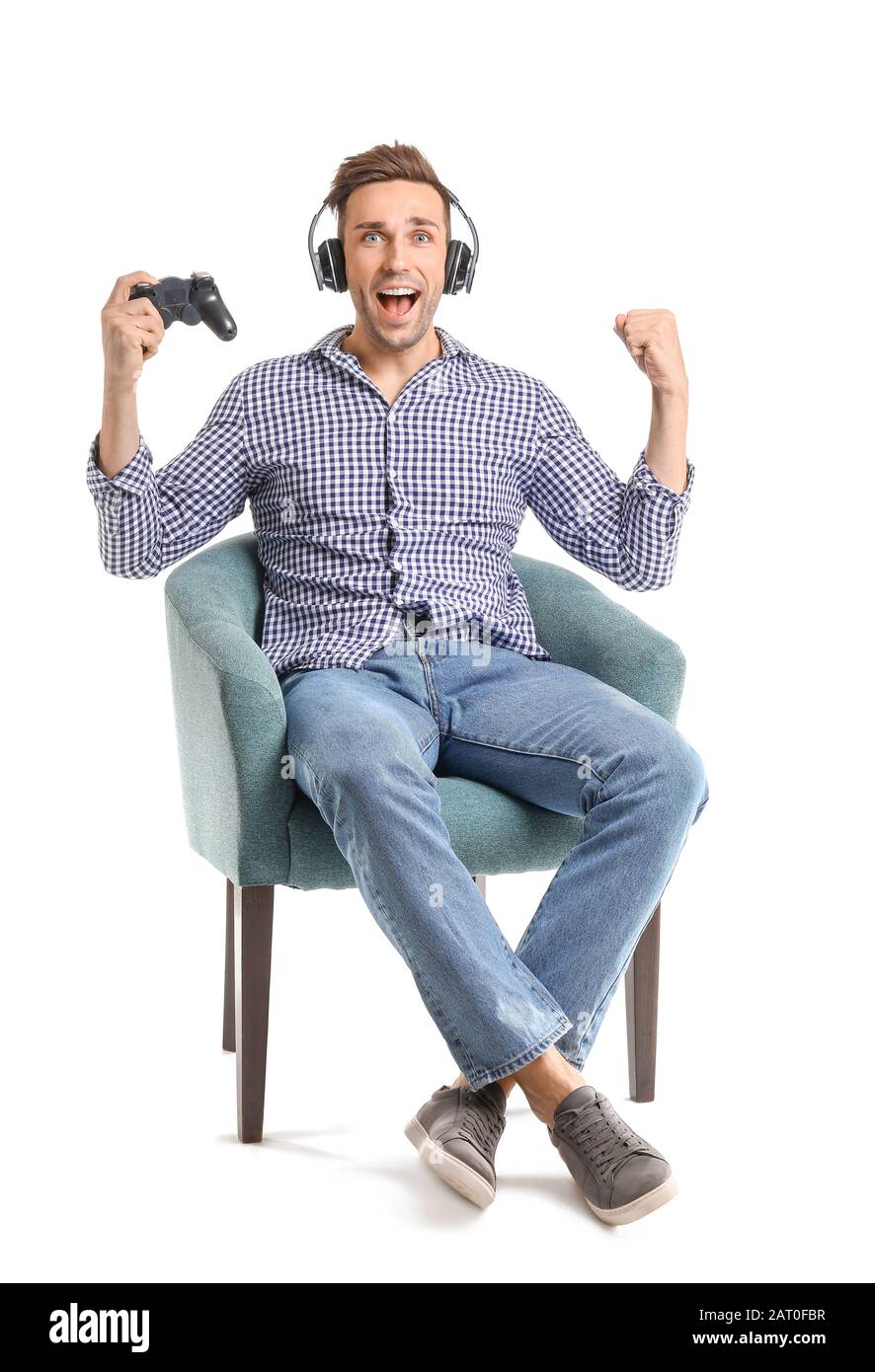 Feliz hombre jugando videojuegos mientras se sienta en sillón sobre fondo  blanco Fotografía de stock - Alamy