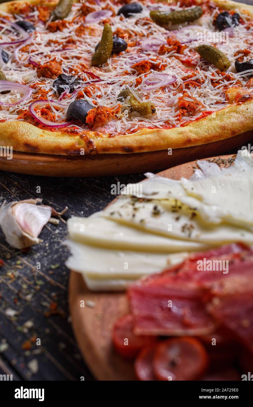 Pizza tradicional. Concepto de almuerzo o cena. Sabrosa comida rápida italiana tradicional sobre mesa de madera. Foto de stock