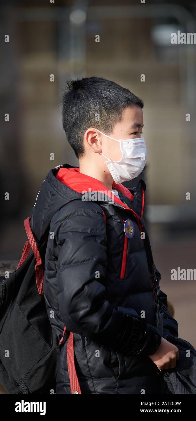 Máscara facial usada por un joven chino en Cambridge, Inglaterra, el 30 de enero de 2020, para prevenir la gripe del coronavirus. Foto de stock