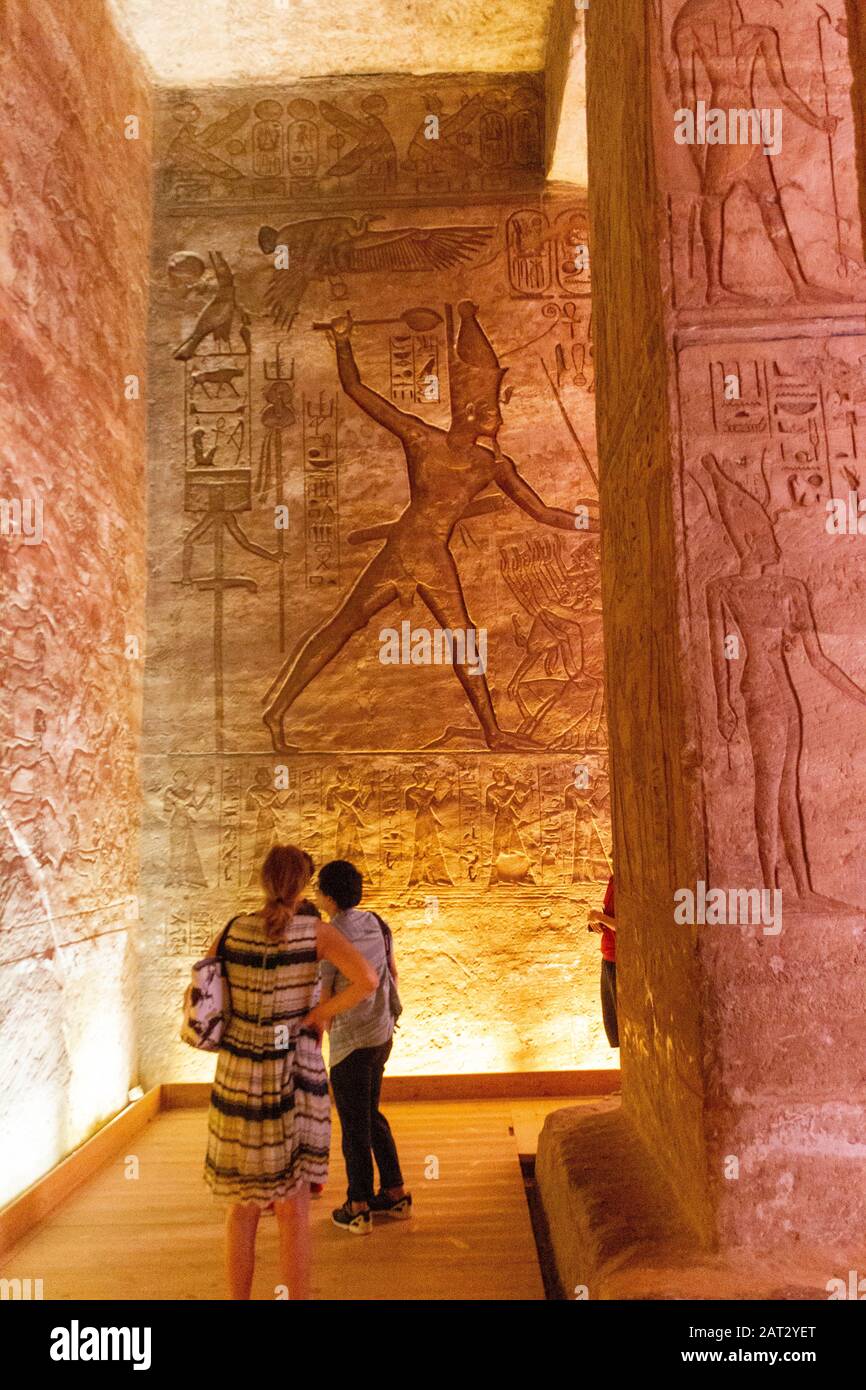 Los turistas miran un muro de jeroglíficos dentro de Abu Simbel Foto de stock