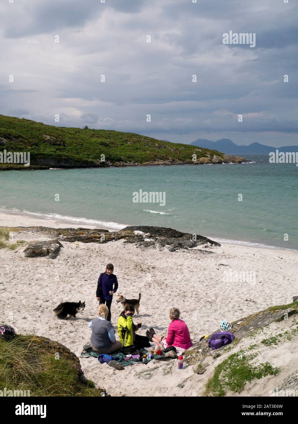 4 mujeres relajándose en la playa de Hebridean Foto de stock