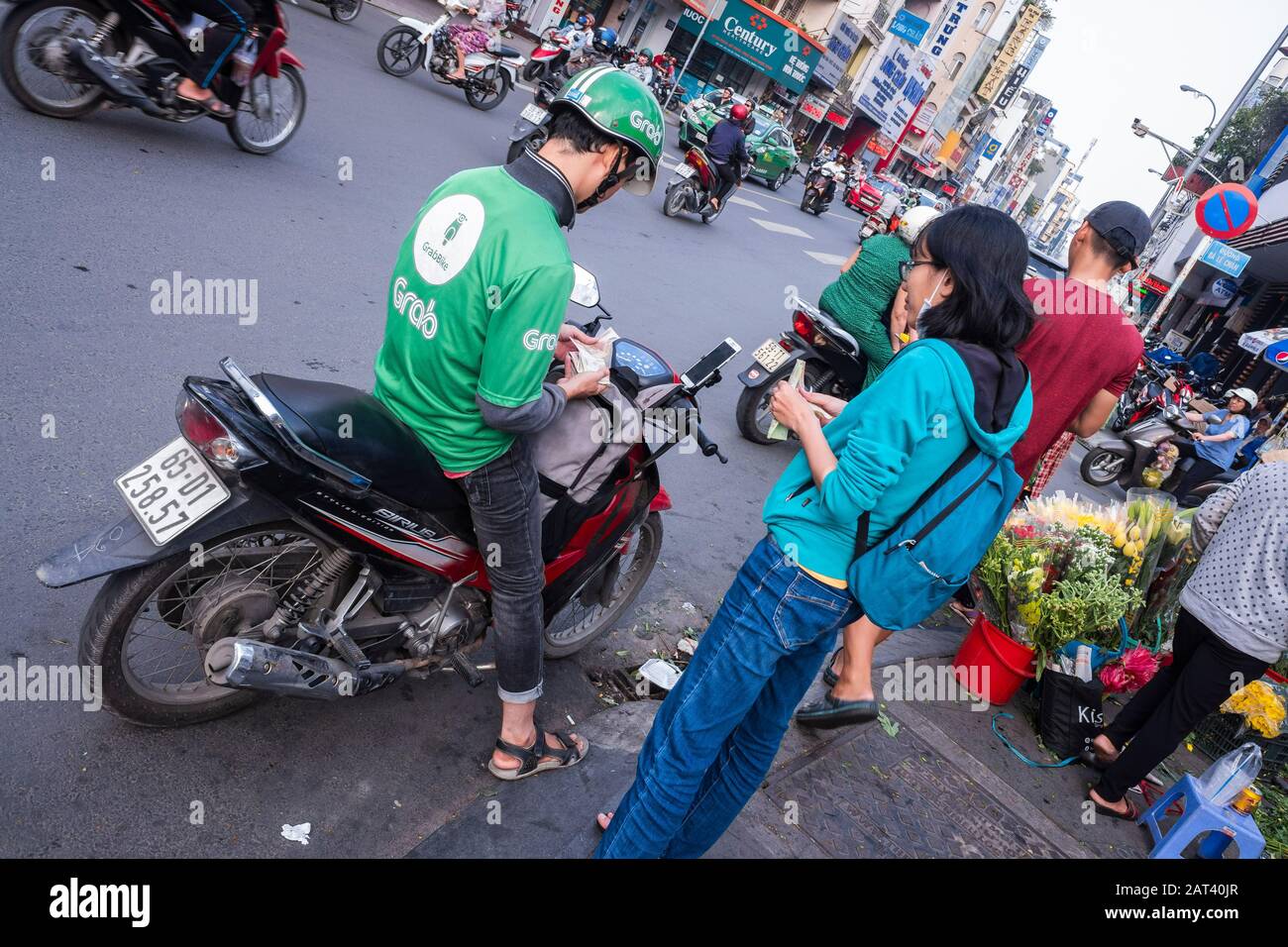 Mujeres jóvenes que utilizan un taxi Grab a través de la aplicación móvil, Ciudad Ho Chi Minh, Vietnam Foto de stock