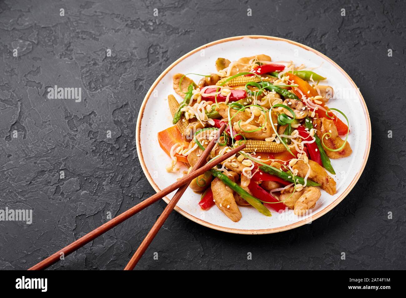 Chop Suey de pollo en plato blanco con fondo de pizarra negro. Chop Suey es  un plato de cocina China americana con diferentes verduras fritas, m de  pollo Fotografía de stock -