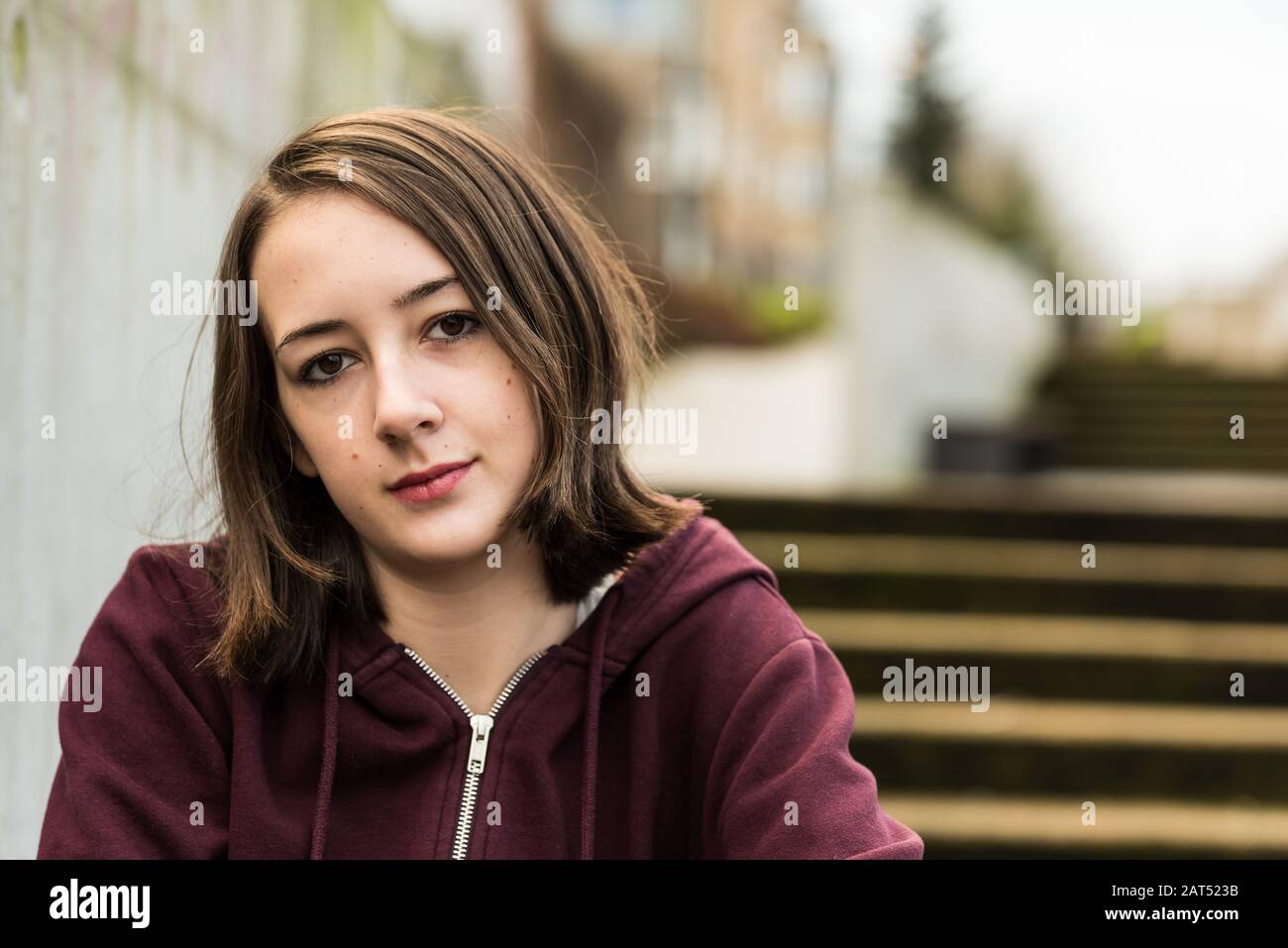 Retrato de una niña universitaria de 17 años sentada en el entrenamiento en una escalera Foto de stock