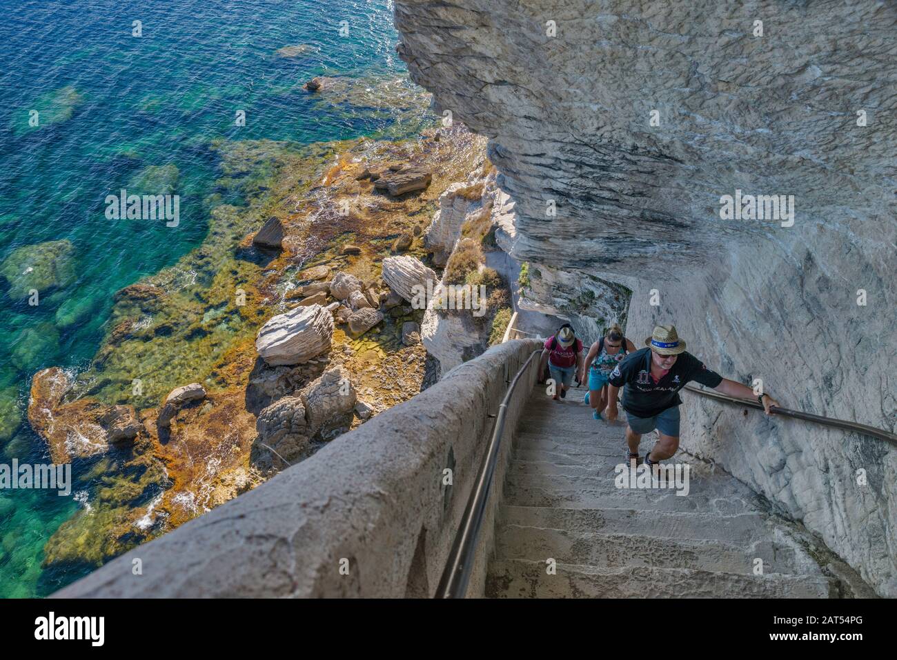 Los visitantes que suben las escaleras en Escalier du roi d'Aragon en el acantilado de piedra caliza sobre el estrecho de Bonifacio en Bonifacio, Corse-du-Sud, Córcega, Francia Foto de stock