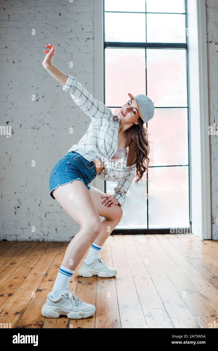 joven pantalones cortos denim y gorra bailando hip-hop Fotografía de - Alamy
