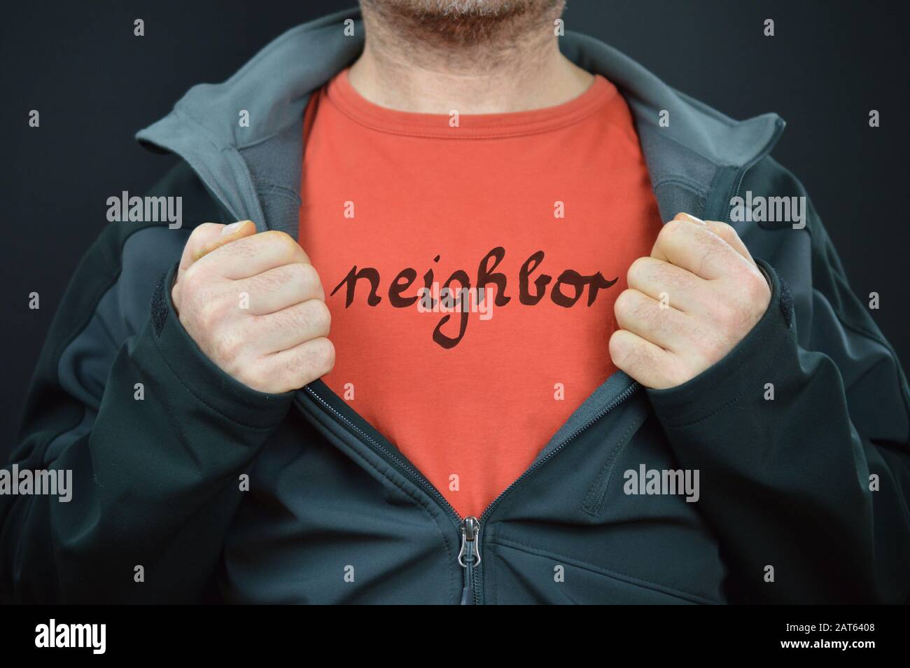 un hombre mostrando su camiseta con la palabra vecino en ella Foto de stock