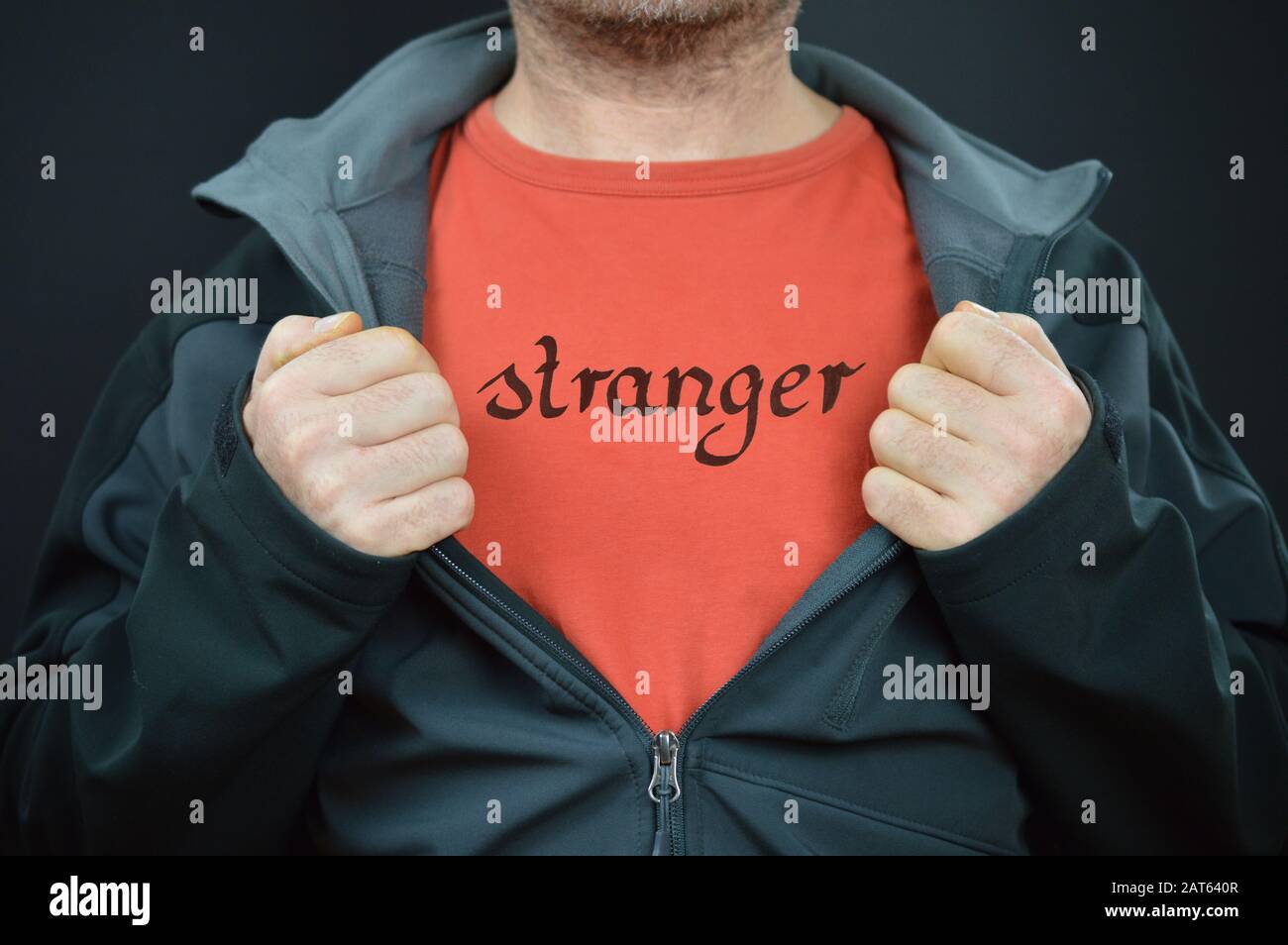 hombre mostrando su camiseta con la palabra forastero escrita en ella Foto de stock