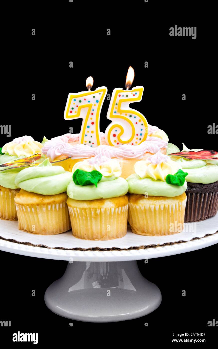 Globo apagado combate Tarta de cumpleaños con crema de mantequilla de color pastel rodeada de  cupcakes. Una vela número 75 está ardiendo en medio de la torta Fotografía  de stock - Alamy