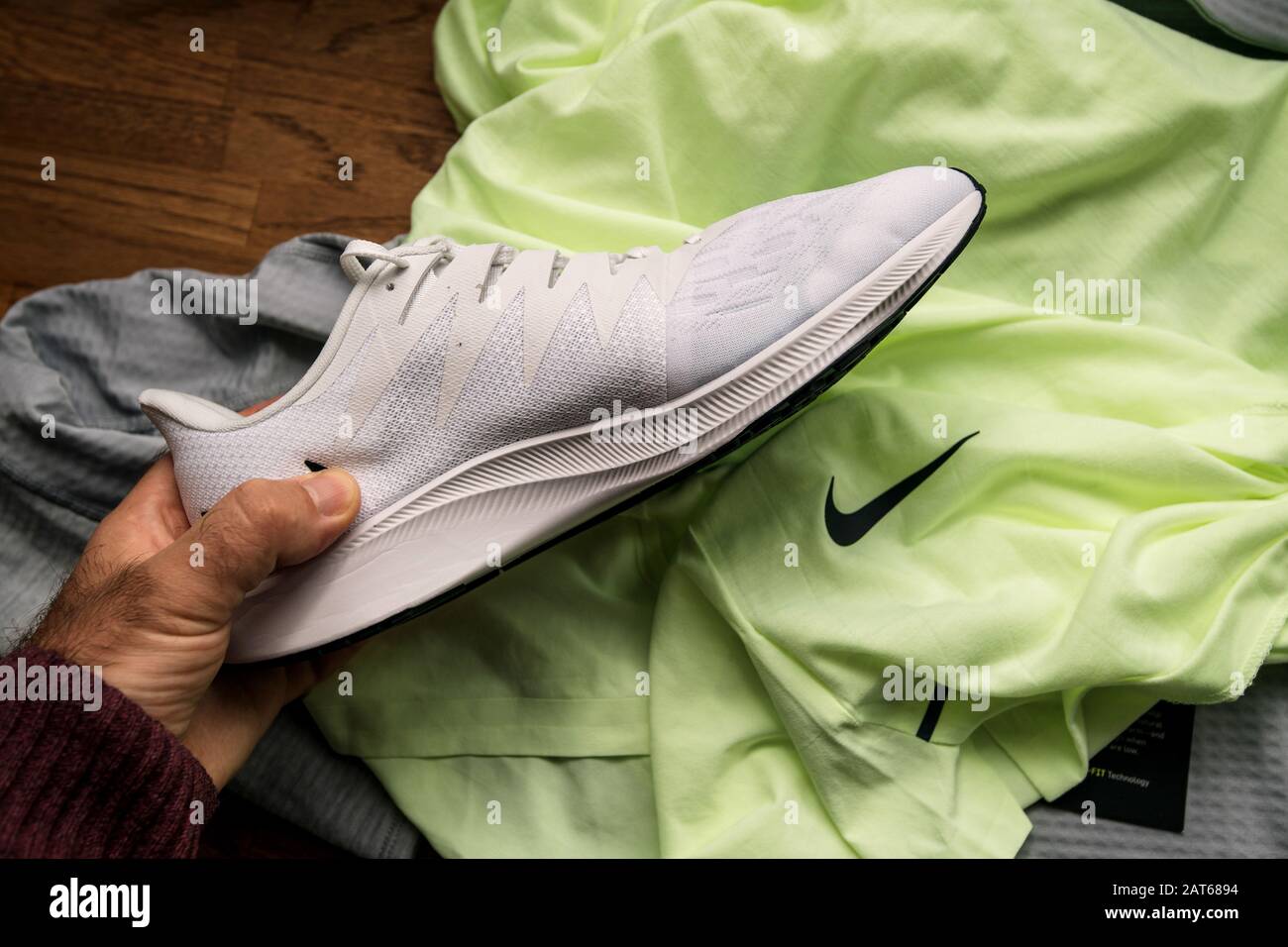 París, Francia - 23 de septiembre de 2019: POV hombre sujetando con la mano  mirando nuevas zapatillas de running profesionales de color blanco  fabricadas por Nike Zoom Rival Fly para mujeres con