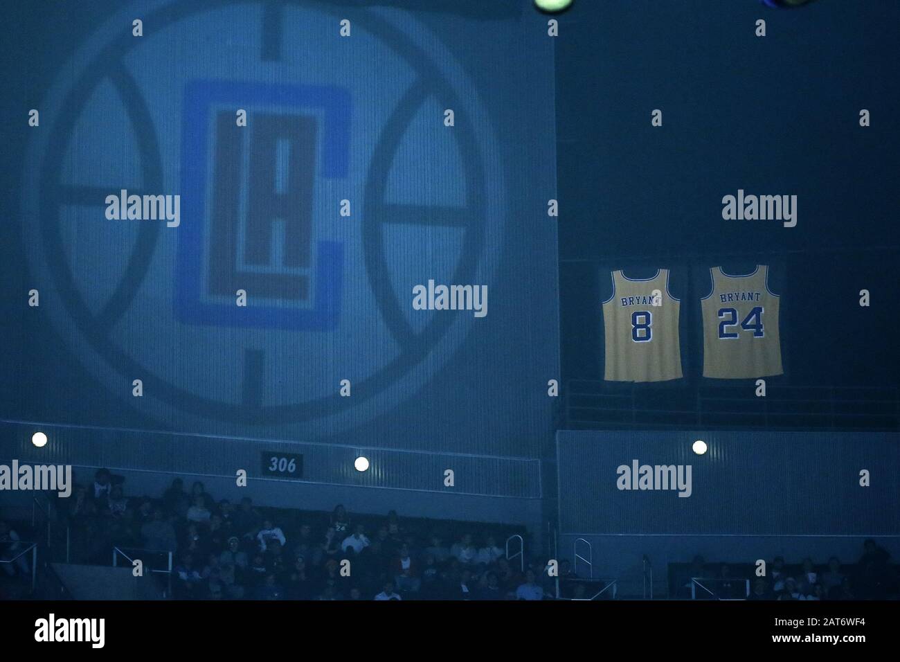 Los Ángeles, California, Estados Unidos. 30 de enero de 2020. Las camisetas  retiradas de finales de los Angeles Lakers Kobe Bryant cuelga sobre la  arena junto a un logo proyectado de los
