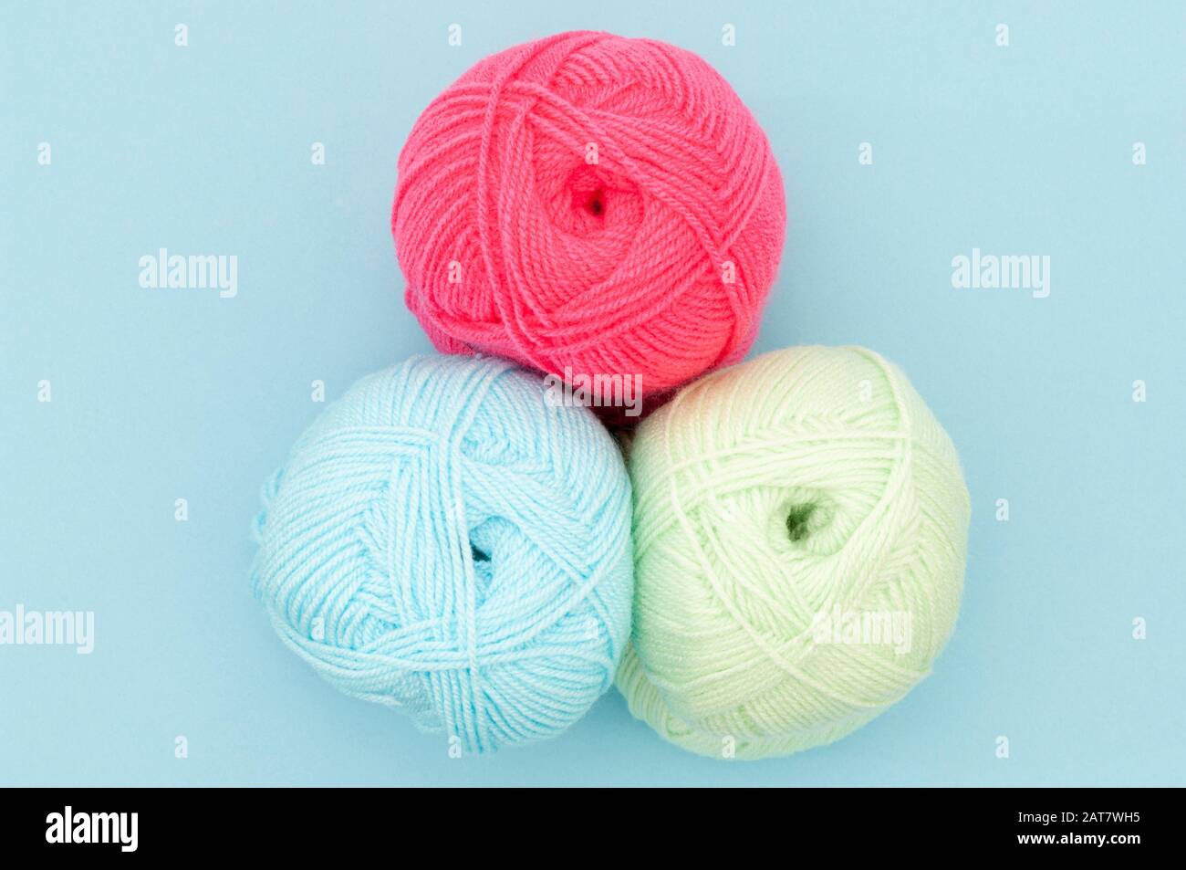 Tres bolas de lana de color sobre fondo azul Foto de stock