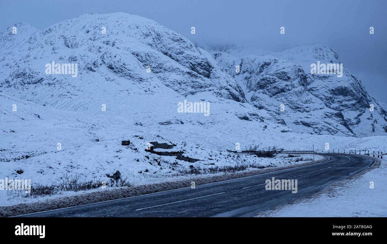 Uno de los viajes por carretera más escénicos de Escocia, el A82 lo recorre por el valle Glencoe en invierno, Foto de stock