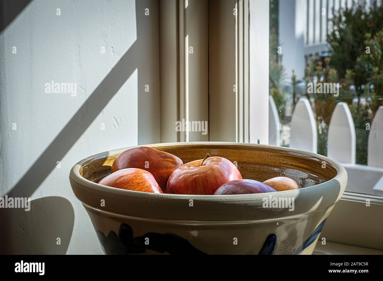Tazón de manzanas en el umbral de la ventana de la cocina de la granja Foto de stock