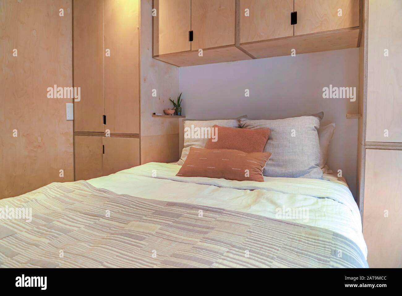 Dormitorio interior de la casa con armarios empotrados sobre y a ambos lados  de la cama Fotografía de stock - Alamy