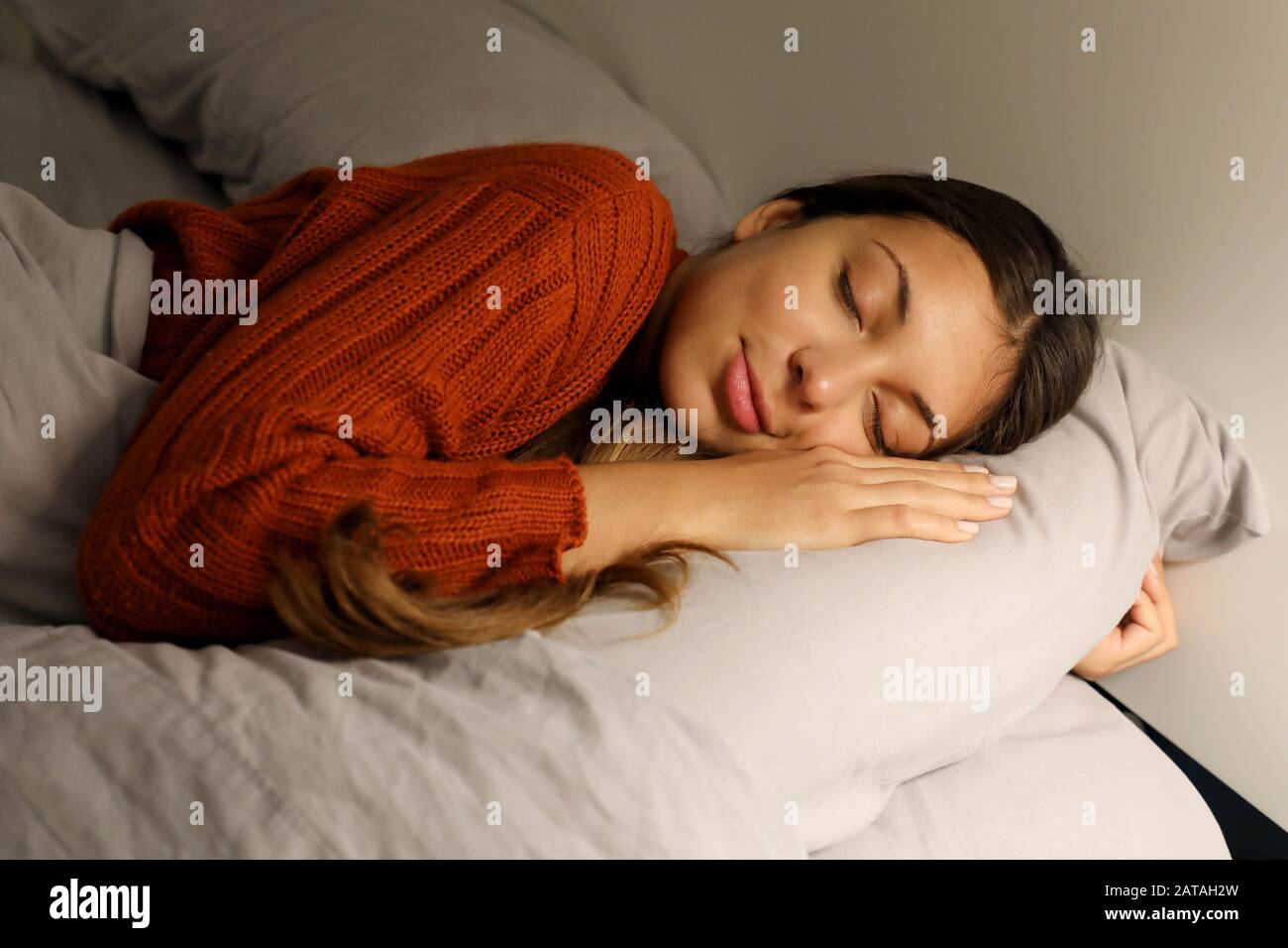 Adolescente duerme abrazando la almohada en la cama por la noche Fotografía  de stock - Alamy