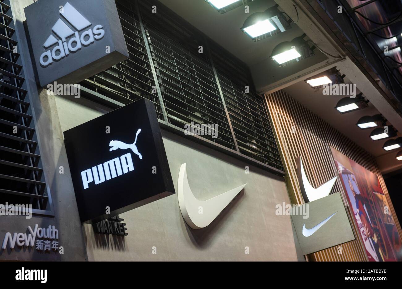 Marcas multinacionales de ropa deportiva Adidas, Puma y los logotipos de Nike en una tienda de Hong Kong Fotografía de stock -