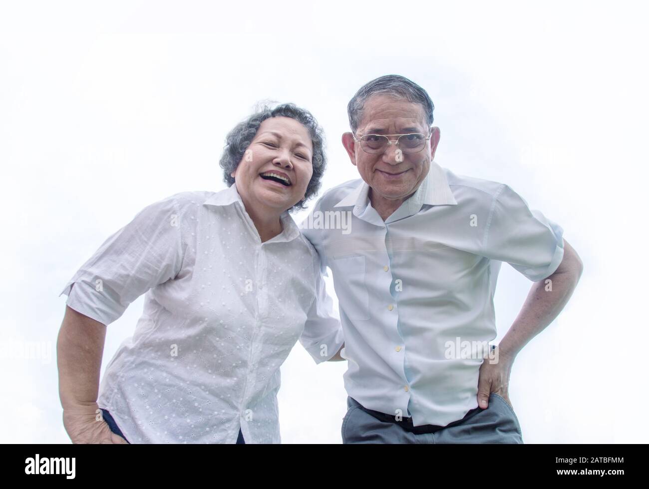 pareja abuela asiática y abuela sonrisa desde la vista inferior en la emoción feliz actuar sobre fondo blanco Foto de stock