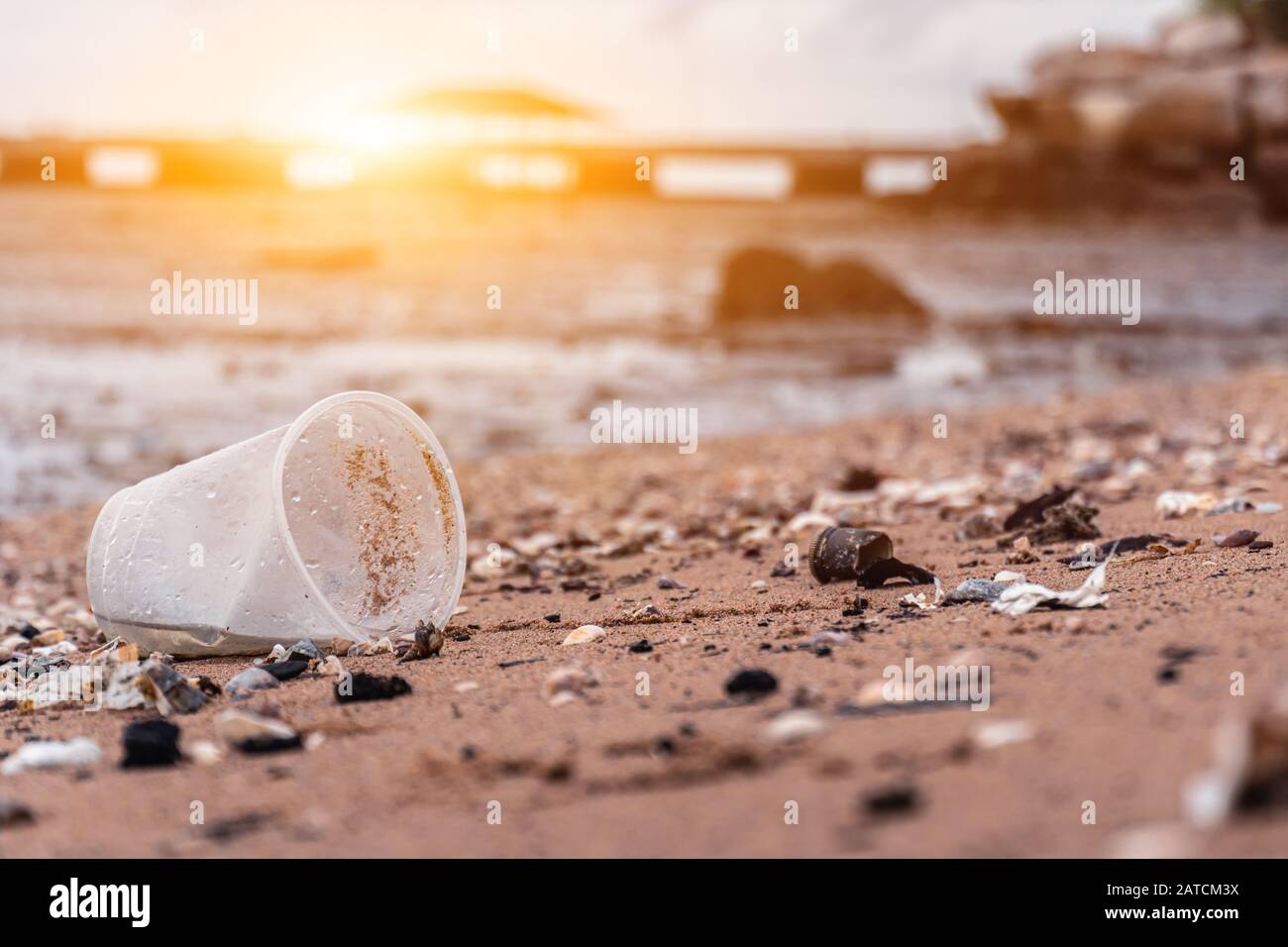 Vasos de plástico y basura en la playa de arena. Conciencia Medioambiental Y Plástica. Concepto Del Día Mundial Del Medio Ambiente. Salva la vida de la tierra. Foto de stock