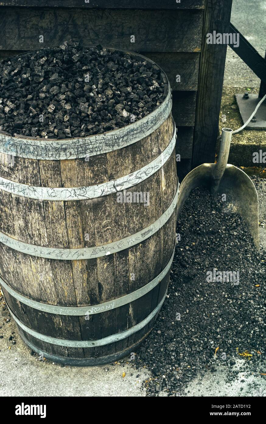 Carbón de leña en un barril y un Shovel, utilizado para Mellowing Tennessee Whiskey by Filtration Foto de stock