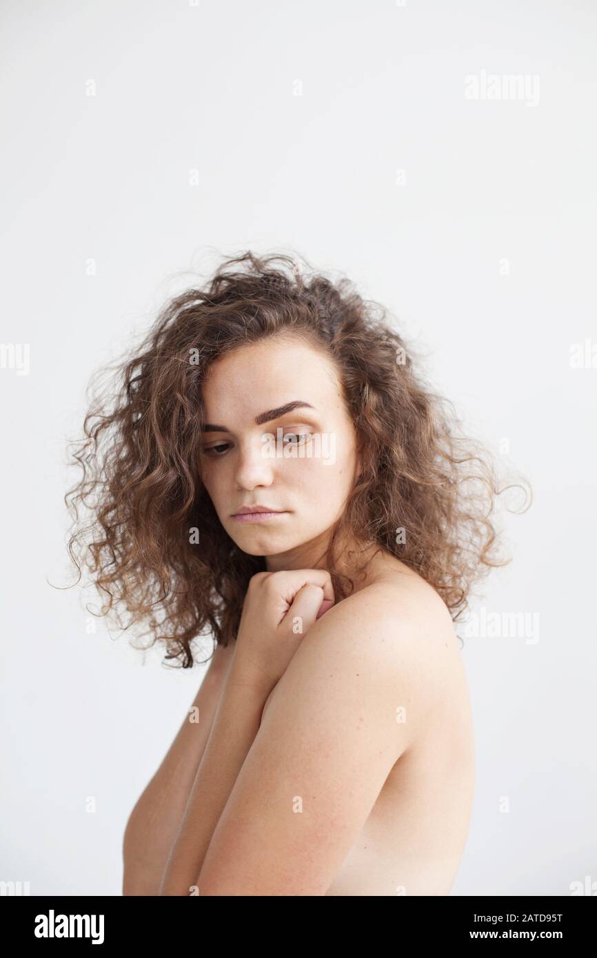 Retrato de una mujer desnuda con sus manos cubriendo sus senos Foto de stock