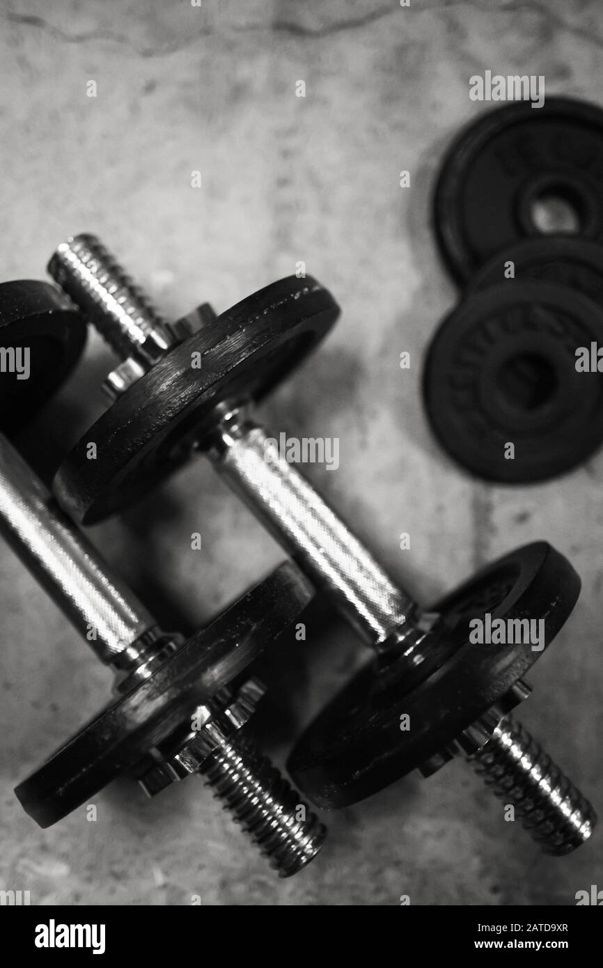 Gimnasio o fondo del bodybuilding de las viejas pesas de hierro en el suelo  gris, del conrete en el gimnasio Fotografía de stock - Alamy