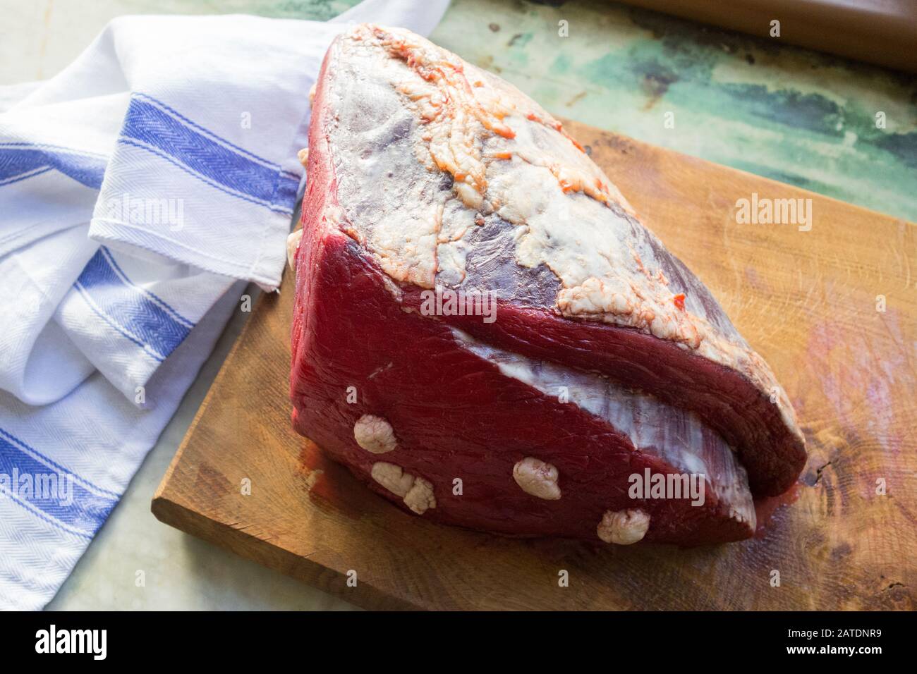 Una junta de carne roja en una tabla de cortar Foto de stock