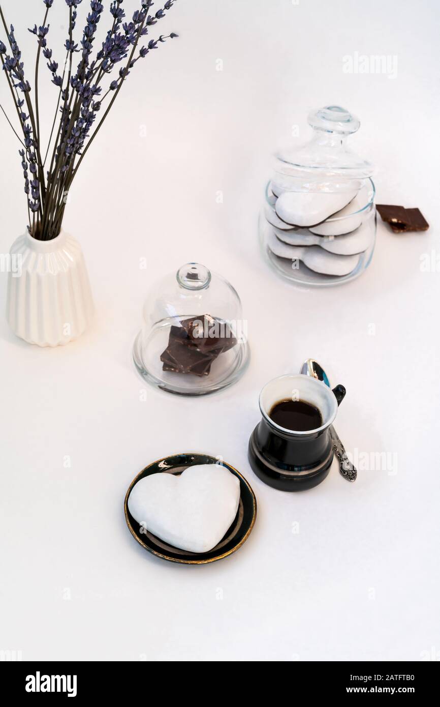 Día de San Valentín todavía vida con taza de café, chocolate y plato con galletas de jengibre en forma de corazón sobre fondo blanco. Concepto de celebración del día de San Valentín Foto de stock