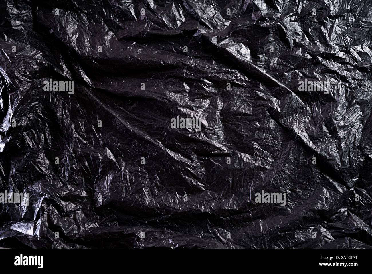 Vista superior de la bolsa de plástico negra y textura de fondo. La  reducción de las bolsas de plástico de un tratamiento natural. Reciclar y  el concepto del Día Mundial del Medio