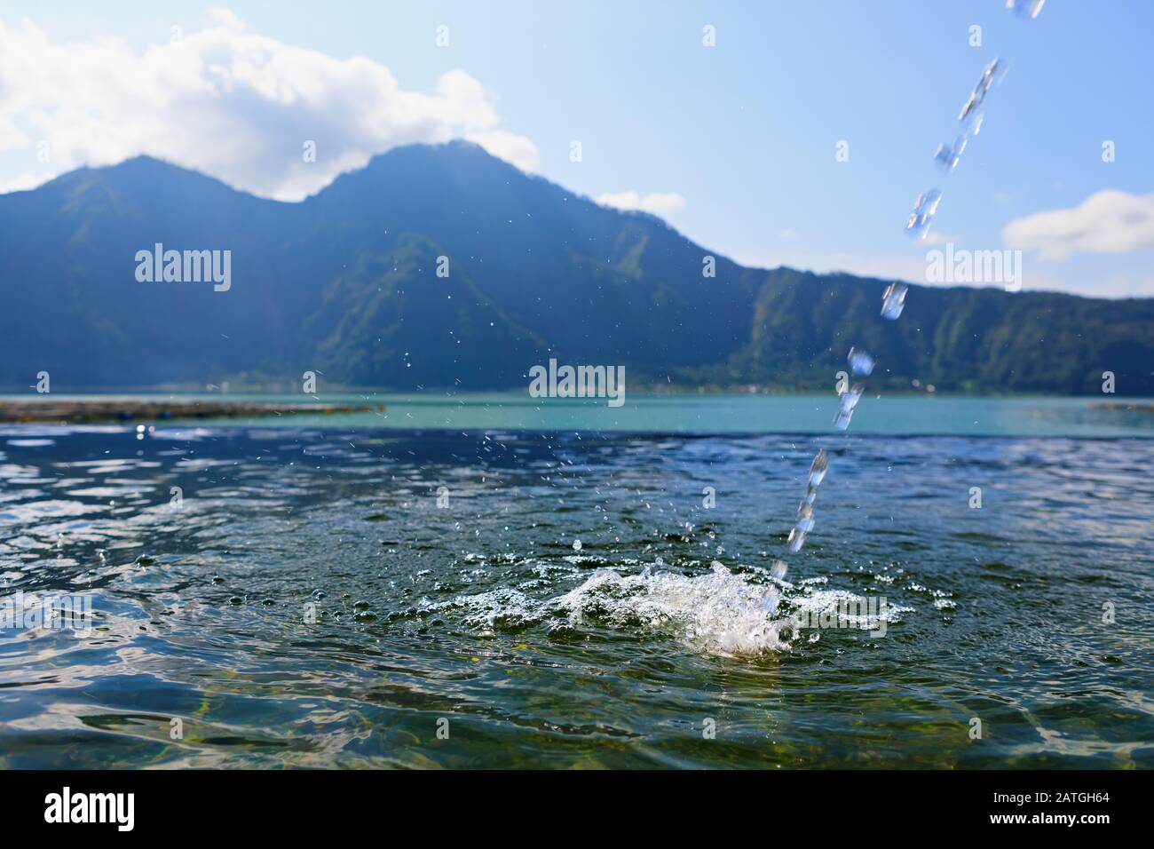 Balneario natural de aguas termales junto al volcán Batur. Agua caliente que fluye a la piscina de borde infinito con un hermoso lago y vistas de la montaña Abang. Destino turístico popular Foto de stock