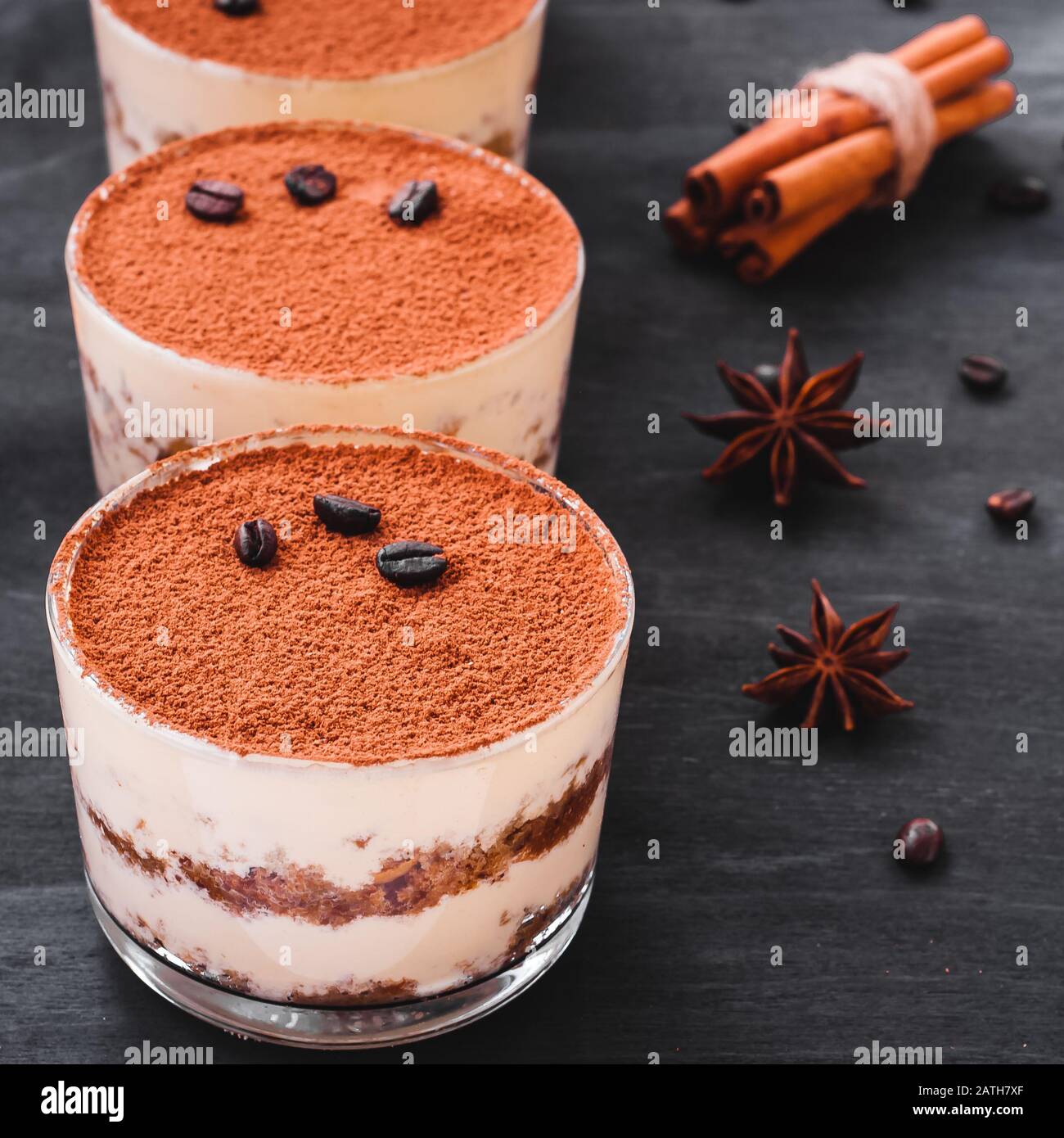 Tiramisú de postre gourmet en un vaso espolvoreado con cacao y decorada con  granos de café sobre un fondo oscuro Fotografía de stock - Alamy
