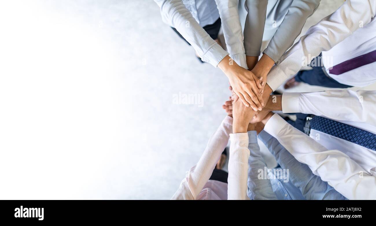 Cerrar vista superior de jóvenes empresarios poniendo sus manos juntas. Pila de manos. Concepto de la unidad y el trabajo en equipo. Foto de stock